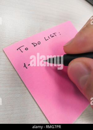 hand writing with pen on a sheet of paper post-it Stock Photo