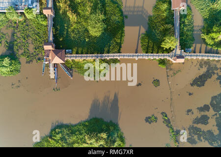 Aerial top view drone shot of bridge in the lake with longtail boats fisherman. Stock Photo
