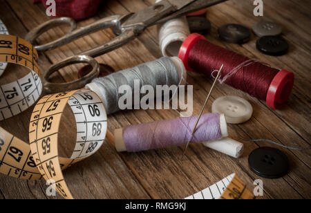 variuous dressmaking tools with, needle and thread, cotton, buttons on old wood Stock Photo