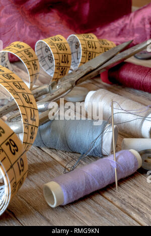 variuous dressmaking tools with, needle and thread, cotton, buttons on old wood Stock Photo