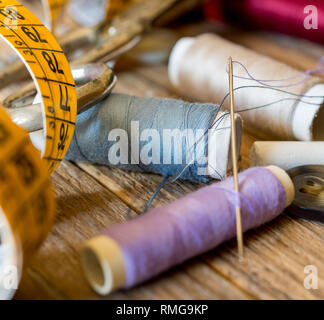 variuous dressmaking tools with, needle and thread, cotton, buttons on old wood Stock Photo