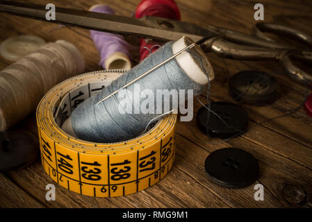 variuous dressmaking tools with, needle and thread, cotton, buttons on old wood Stock Photo