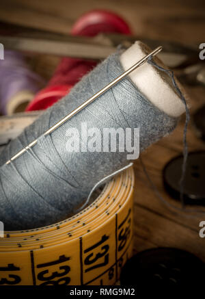 variuous dressmaking tools with, needle and thread, cotton, buttons on old wood Stock Photo