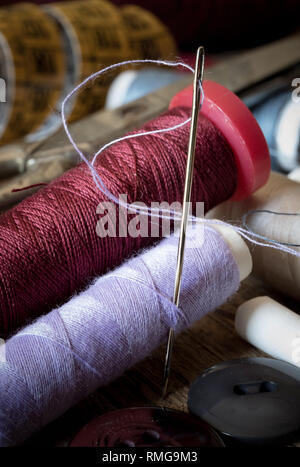variuous dressmaking tools with, needle and thread, cotton, buttons on old wood Stock Photo