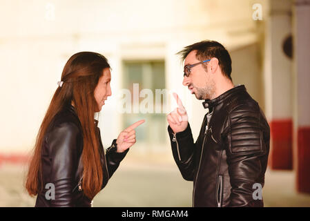 Couple arguing with aggressive boyfriend threatening his wife, concept of male abuse. Stock Photo