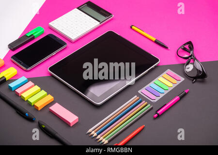 Picture of modern artspace with tablet, glasses, stationery and smartphone on pink and black background. Flat lay style Stock Photo