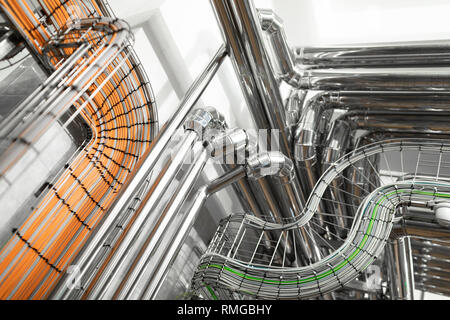 Steel pipelines and cables in factory interior as chemical industry background concept Stock Photo
