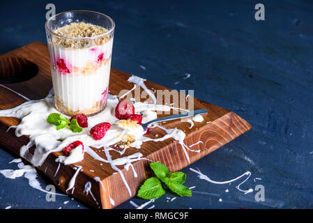 Sweet raspberry dessert in glass with biscuit,berry fruit and whipped cream, blank space. Stock Photo