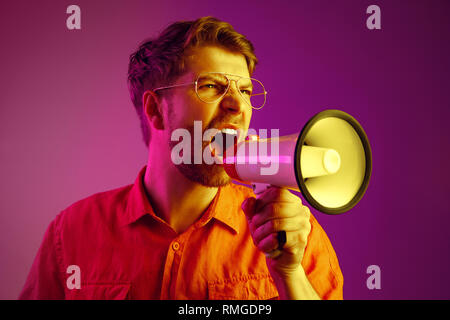 man making announcement with megaphone at gold studio Stock Photo