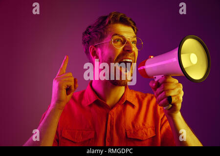 man making announcement with megaphone at gold studio Stock Photo