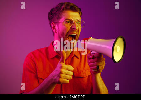 man making announcement with megaphone at gold studio Stock Photo