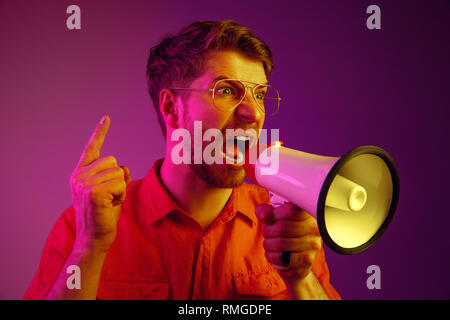 man making announcement with megaphone at gold studio Stock Photo