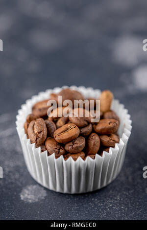 Coffee beans in the package from candy on a dark background. Close-up. Stock Photo