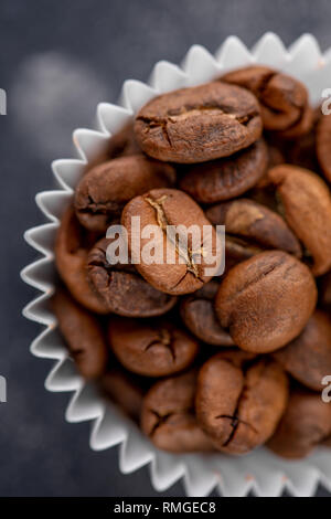 Coffee beans in the package from candy on a dark background. Close-up. Stock Photo