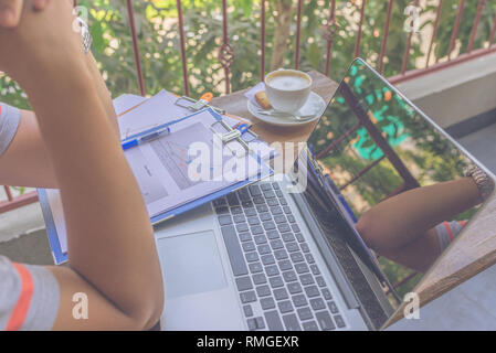Young man thinking in front of laptop Stock Photo