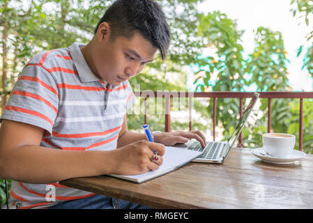 Asian man writing on notebook or document Stock Photo