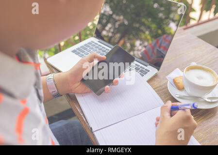 Young freelancer writing into the notes Stock Photo