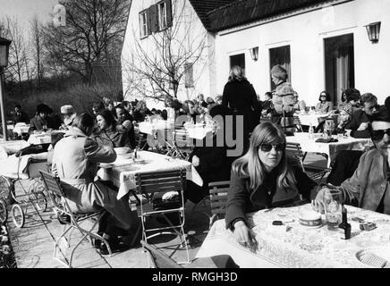 Many guests sit on the sun terrace of the beer garden Aumeister in the Englischer Garten in Munich.