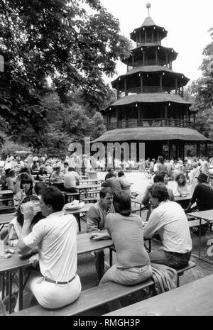 Many people sit in the beer garden at the Chinese Tower in the Englischer Garten in Munich. Stock Photo