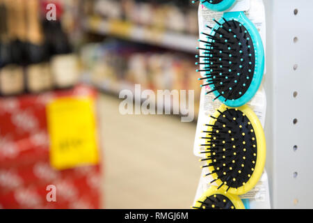 Colored hair brushes are sold. Combs for hair on a stand in a supermarket with copy space. Stock Photo