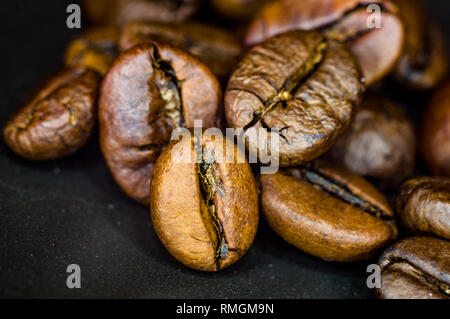 Brown roasted coffee beans on black background, close-up, macro Stock Photo