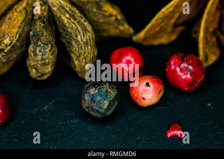 Star anise and multi-colored balls fragrant peppers on a black background, close up, macro Stock Photo