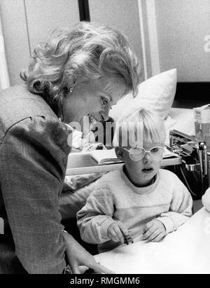 Hannelore Kohl, chair of the Kuratorium ZNS (today: ZNS - Hannelore Kohl Foundation for Persons Injured with Damage to the Central Nervous System), visits the newly founded neurosurgical department at the St Elisabeth Hospital in Guetersloh. Here, with a five-year-old girl suffering from damage to the central nervous system. Stock Photo