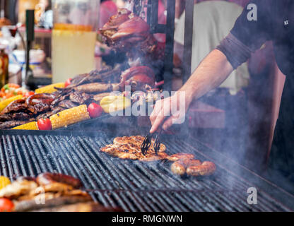 Chef is grilling perfect steak on cast iron grate. Street food Stock Photo