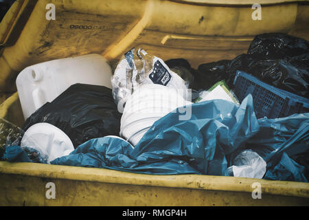 gelbe Mülltonne mit Plastikmüll. yellow garbage bin with plastic waste. Stock Photo