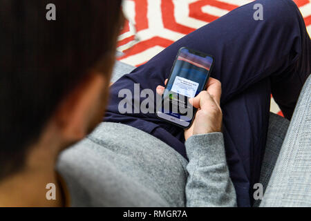 LONDON, UK - SEP 21, 2018: Man using the new Apple iPhone Xs with the immense OLED retina display and a12 bionic chip, looking over the app application  Stock Photo