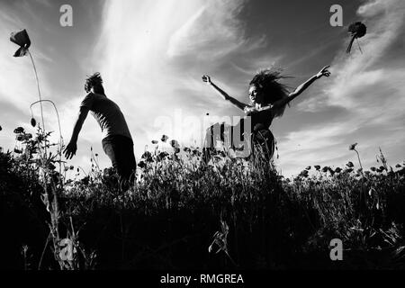 man and girl in red poppy field Stock Photo