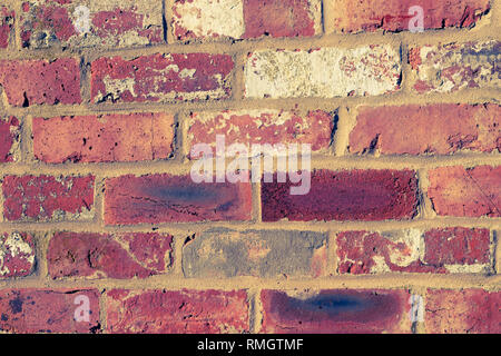 close up of a brick wall that has been build with old bricks, duo toned in yellow and blue Stock Photo