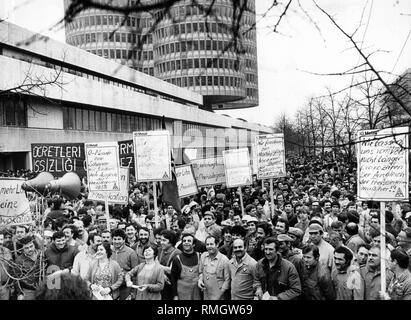 Demonstration of around 10,000 workers from the BMW and Sueddeutsche Bremsen AG against the negotiation of metalworkers. In the front, several migrants. After a speech given by the chairman IG Metall, the workers went back to work. In the background, the skyscraper of the BMW. Stock Photo