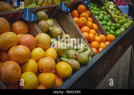 Variety of organic fresh fruits including oranges, apples and peaches on sale at a stall in a local farmer market. Seasonal produce. Landscape format. Stock Photo