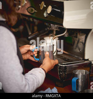 London, UK - June, 2018. A barista preparing a latte at a stall in Borough Market, one of the oldest and biggest food market in London. Stock Photo