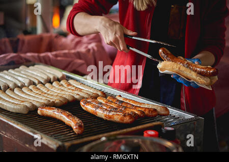 German bratwurst sausages cooked on a grill in a local farmer market. Landscape format.