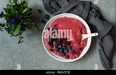 Smoothy of fresh bog blueberries and raspberries in bowl near napkin Stock Photo