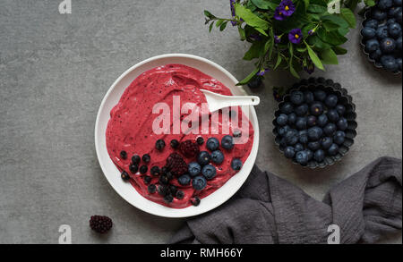 Smoothy of fresh bog blueberries and raspberries in bowl near napkin Stock Photo