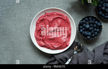 Smoothy of fresh bog blueberries and raspberries in bowl near napkin Stock Photo