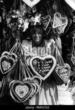 Woman selling gingerbread hearts at the Oktoberfest in Munich. Stock Photo