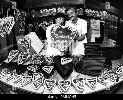 Gingerbread maker selling individually decorated hearts at the Oktoberfest in Munich. Stock Photo