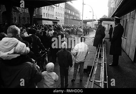 At the border crossing point Invalidenstrasse in East Berlin, citizens flock past a border guard of the GDR in the western part of the city. Stock Photo