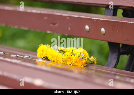 Hallo, summer. A wreath of dandelions on a wooden bench. In the Park in the summer. Romantic date, Declaration of love. Stock Photo