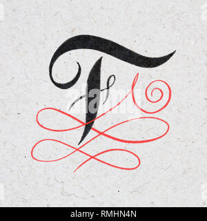 Calligraphic letter F with flourishes on kraft paper Stock Photo