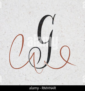 Calligraphic letter G with flourishes on kraft paper Stock Photo