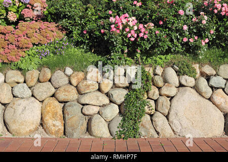 Frisian stone wall planted with flowers Stock Photo