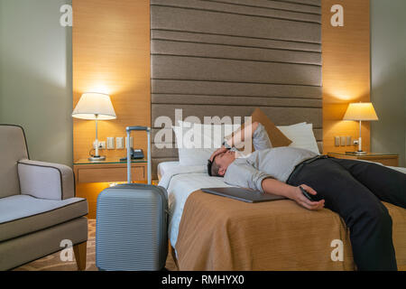 Tired businessman sleeping in hotel room Stock Photo