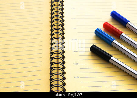 Open diary, planner and a set of markers on a close-up table Stock Photo