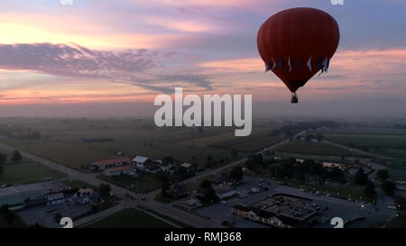 Aerial View of Sunrise with Hot air Balloons Taking Off with Glow as Seen by a Drone Stock Photo