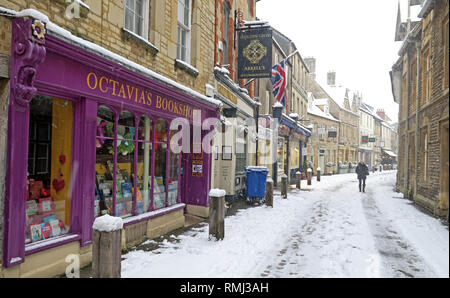 View up Black Jack Street, Octavias Bookshop, to Church of St. John Baptist, winter snow Cirencester town centre, Gloucestershire, England, GL7 2AA Stock Photo